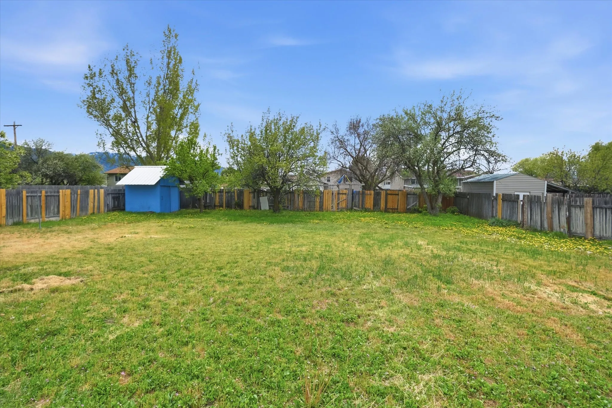 Fenced backyard with an outbuilding