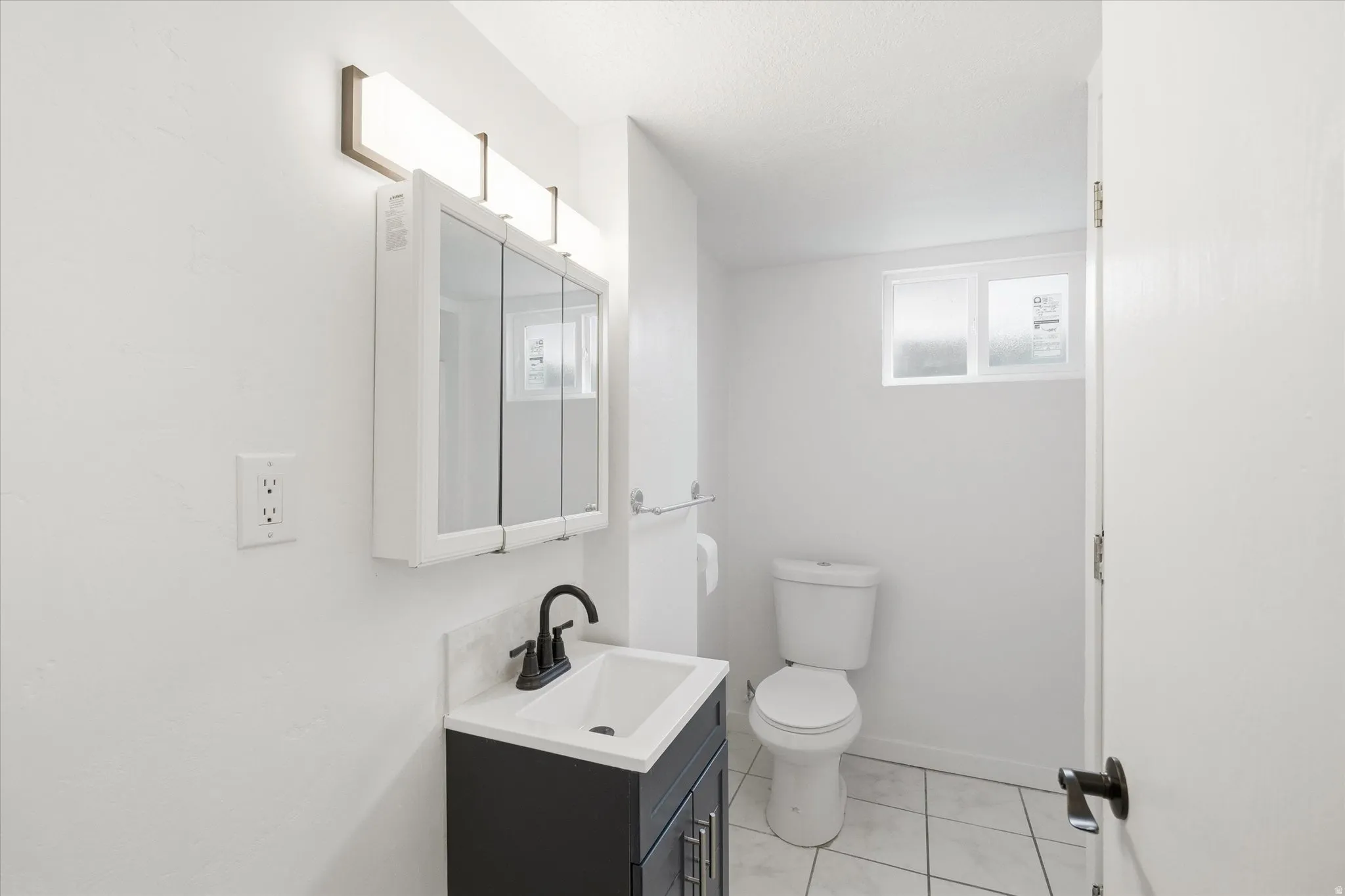 Half bath featuring vanity and light tile patterned floors