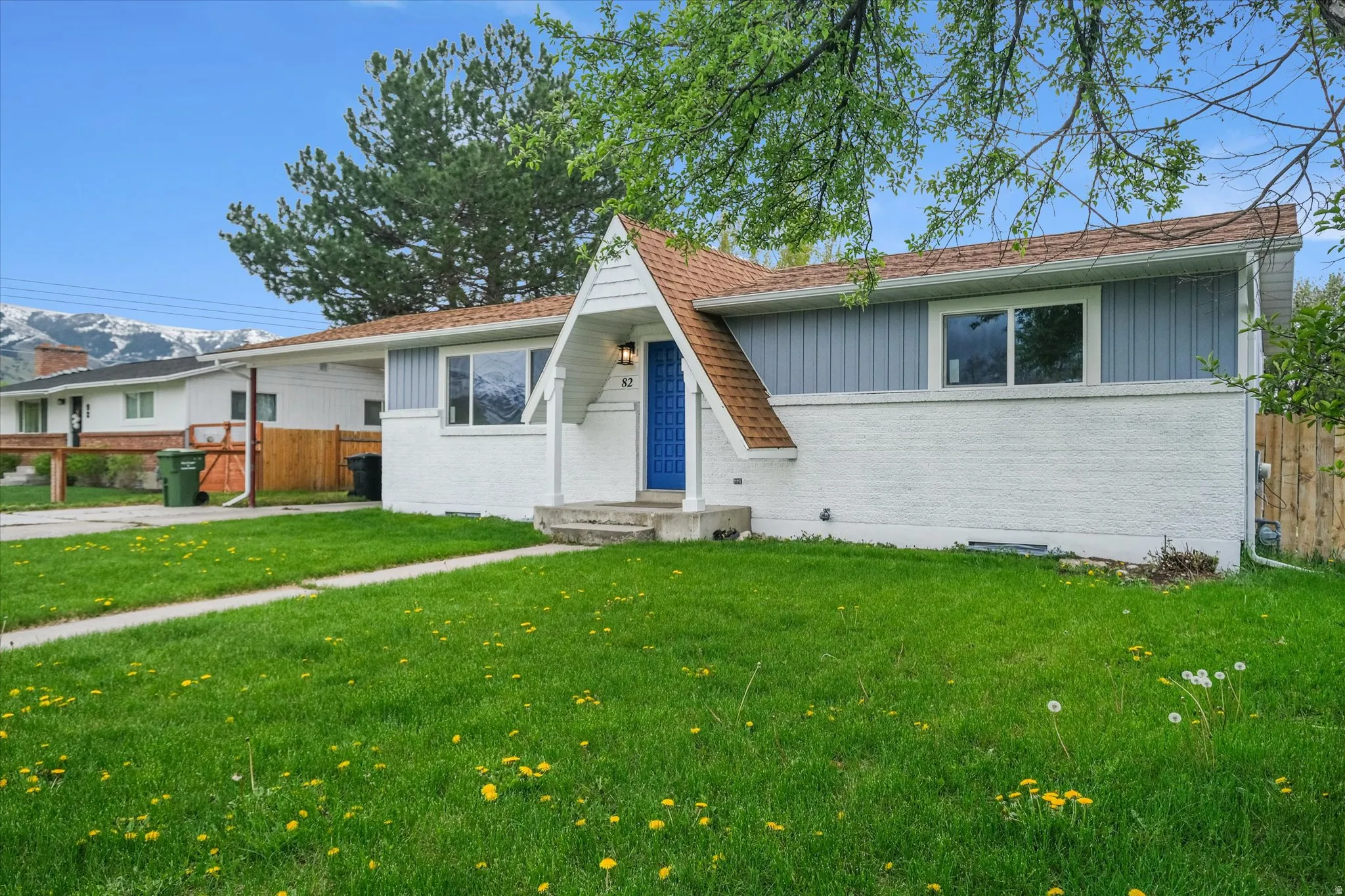 View of front of property with brick siding, board and batten siding, and roof with shingles