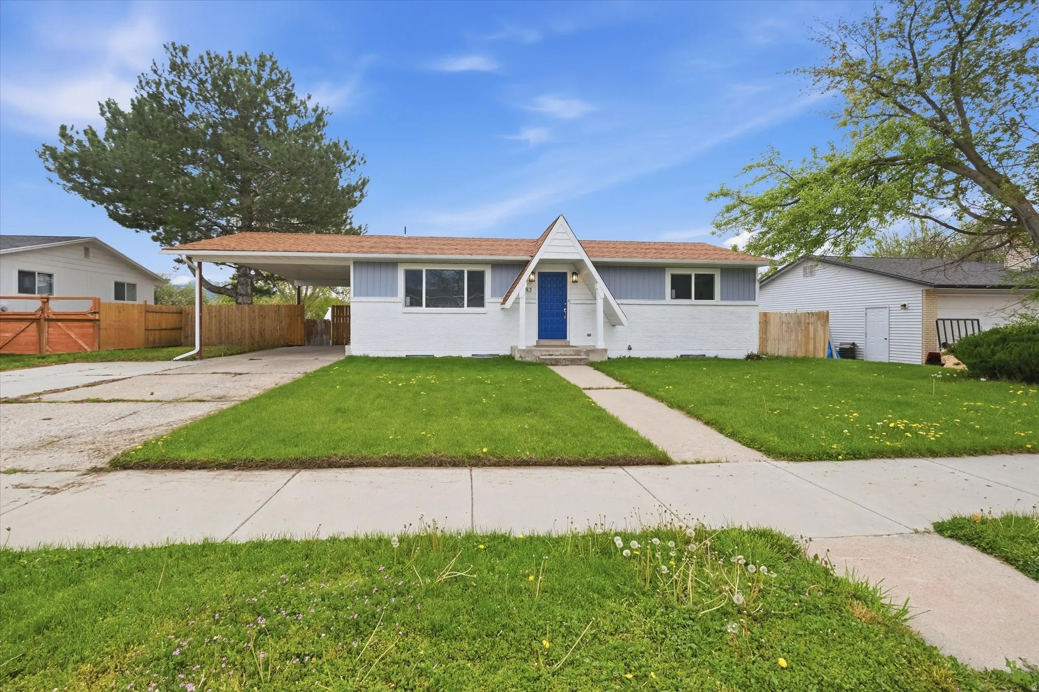 View of front of home featuring a carport, driveway, and brick siding