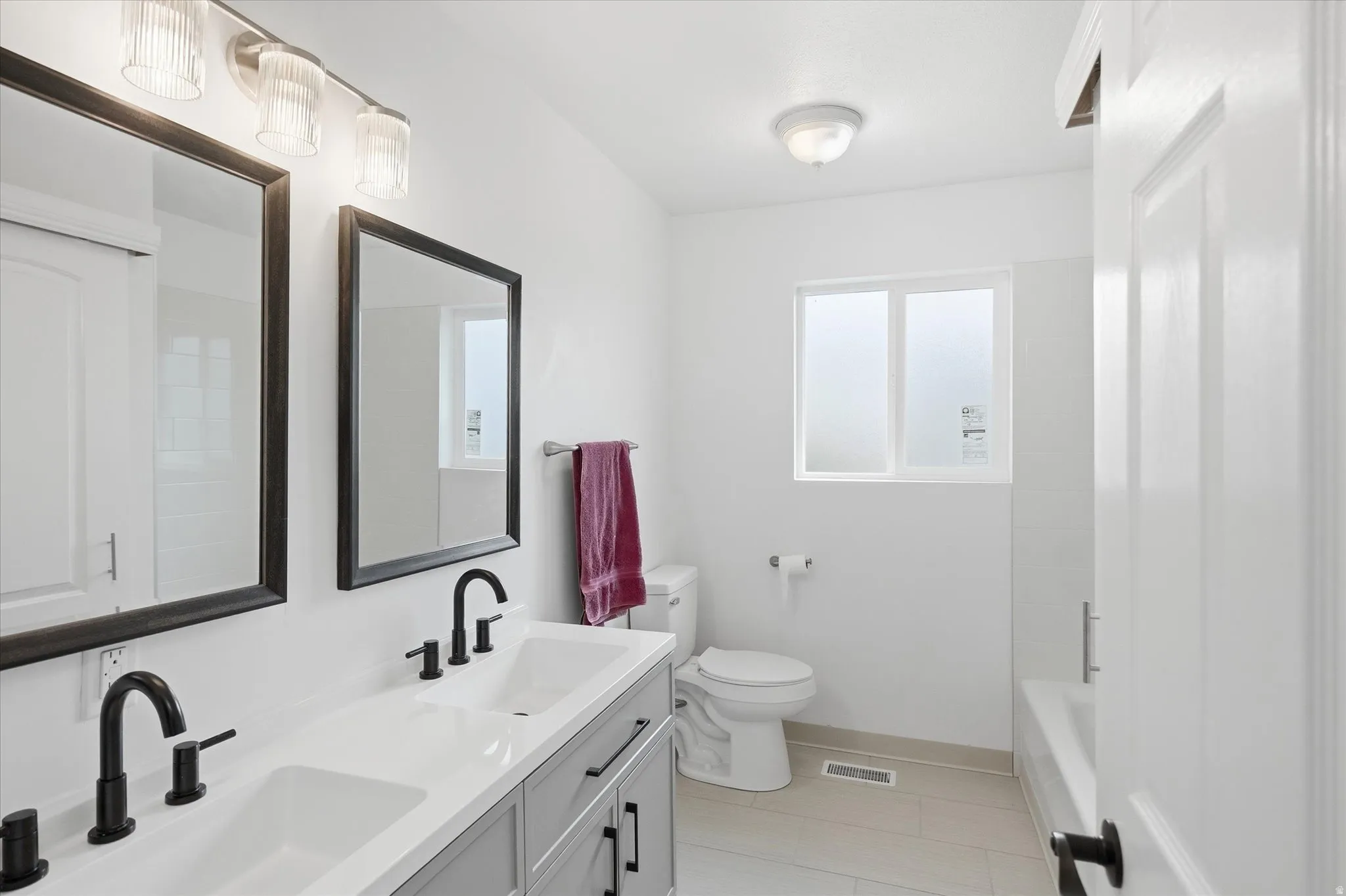 Bathroom featuring double vanity and toilet