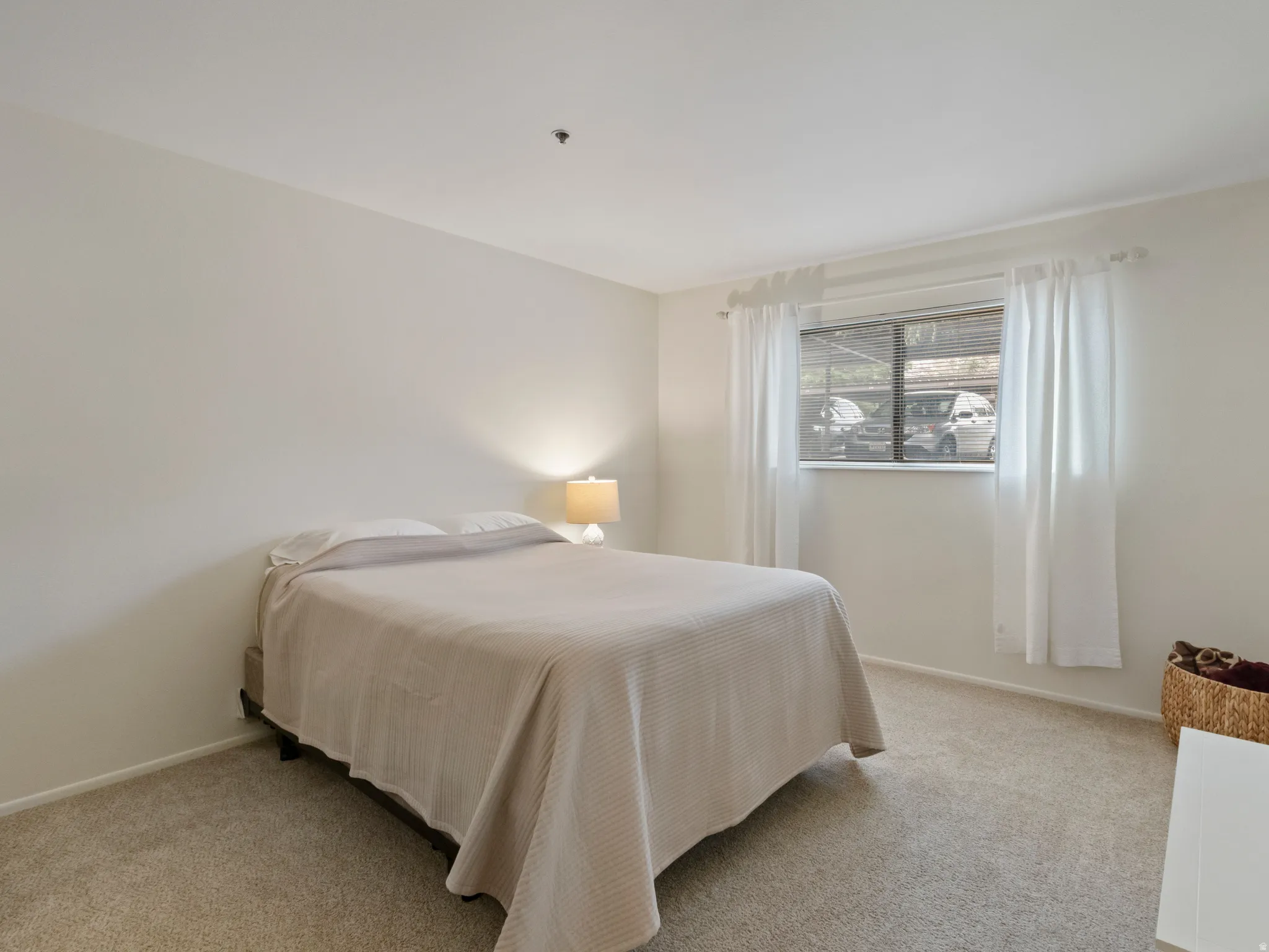 Bedroom featuring light carpet and baseboards