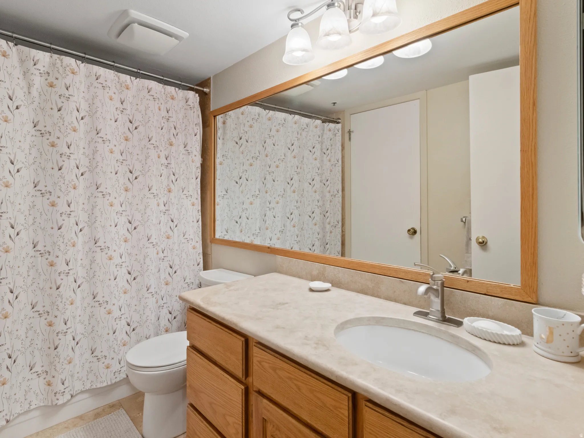 Full bath with vanity, curtained shower, and light tile patterned floors