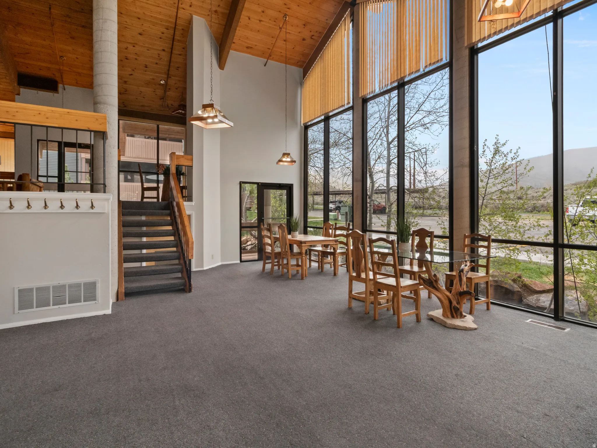 Dining room with dark carpet and a high wooden ceiling