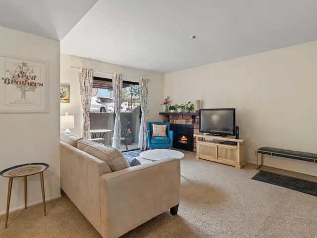 Living room with light carpet and a stone fireplace