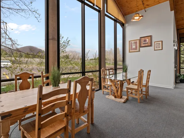 Dining space featuring carpet flooring, plenty of natural light, and a vaulted wood ceiling