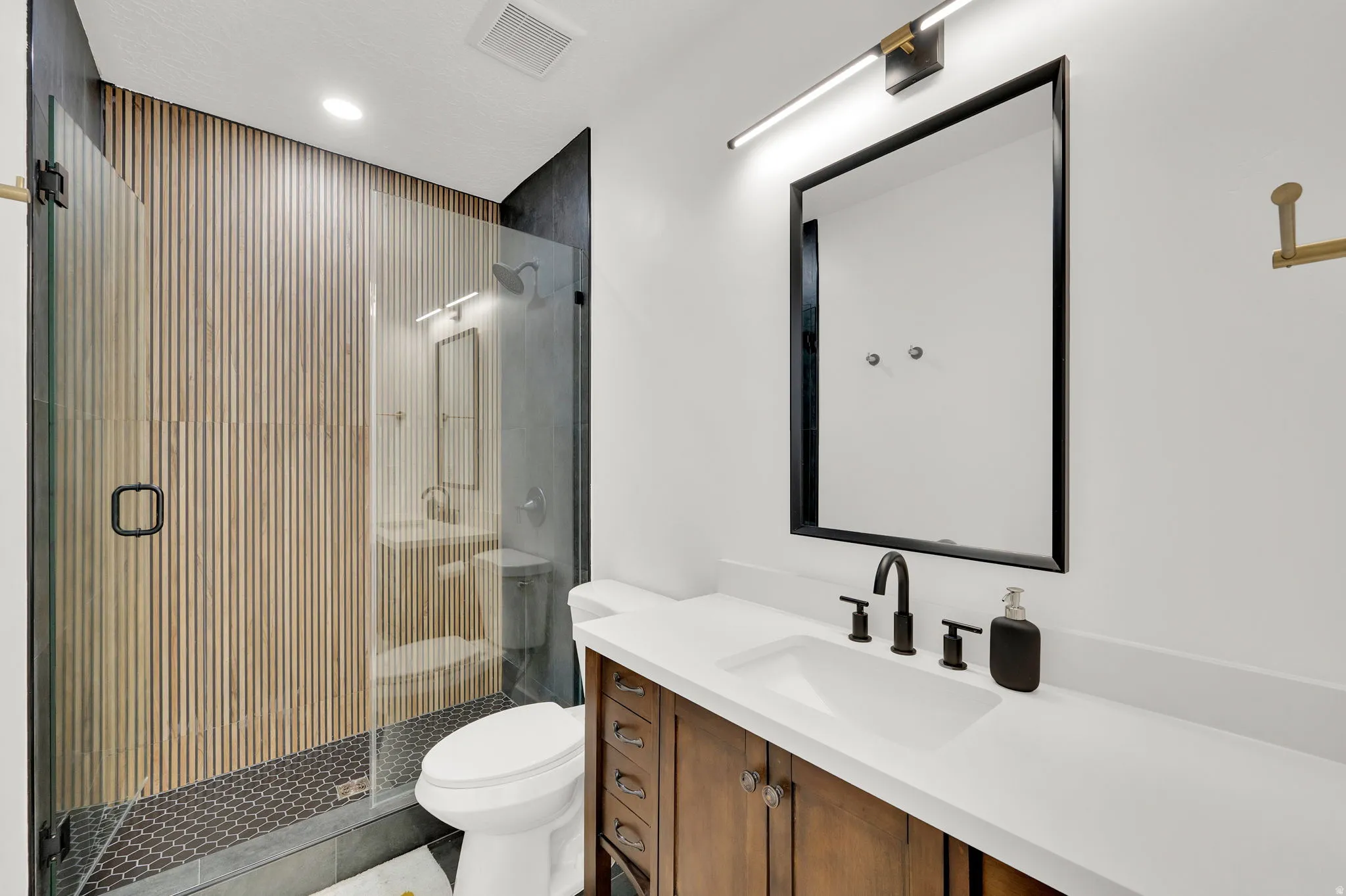 Bathroom featuring vanity, a stall shower, recessed lighting, and tile patterned flooring