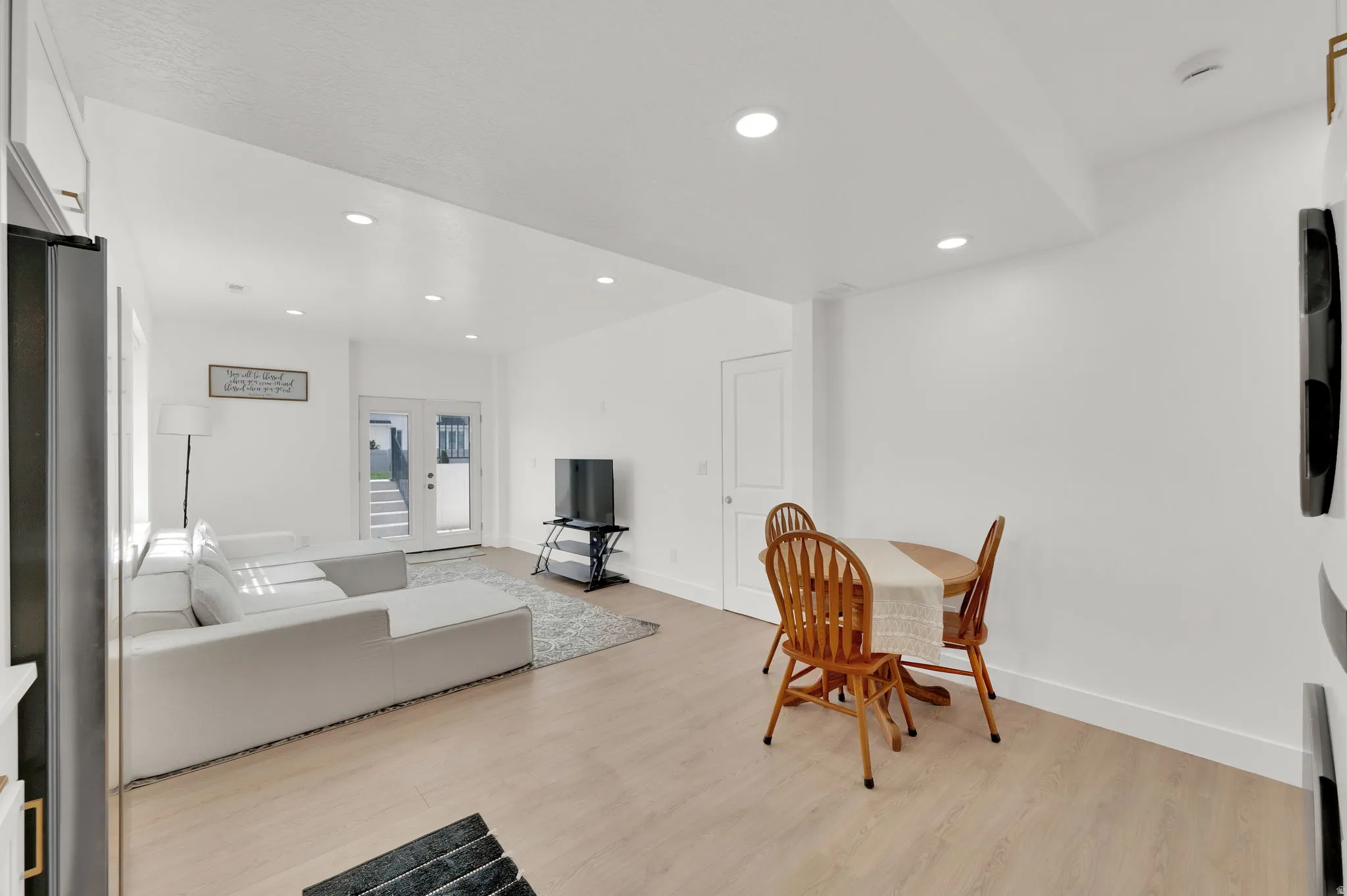 Dining area with light wood-style floors and recessed lighting