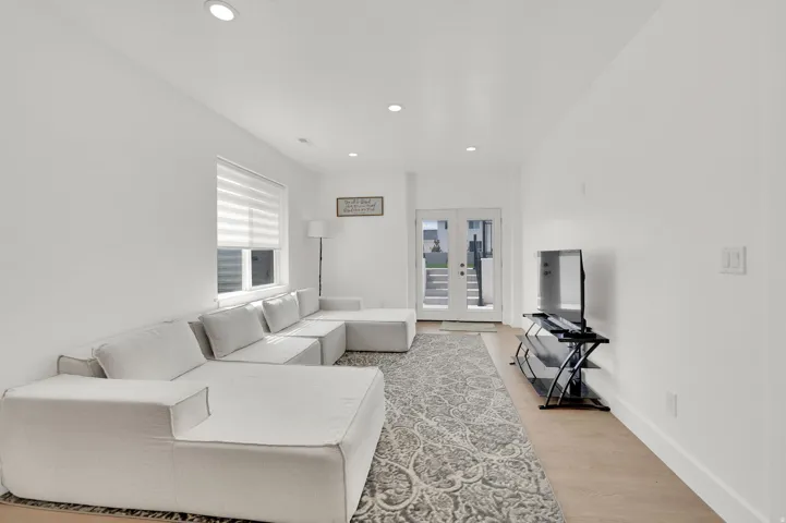 Living area with french doors, light wood-style floors, and recessed lighting