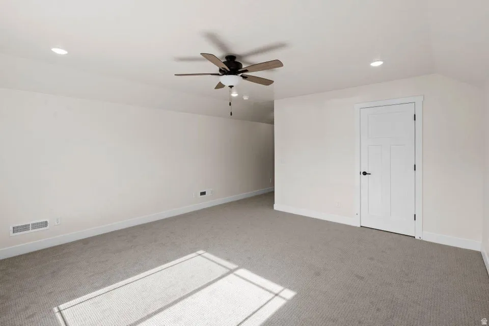 Additional living space with vaulted ceiling, carpet flooring, a ceiling fan, and recessed lighting