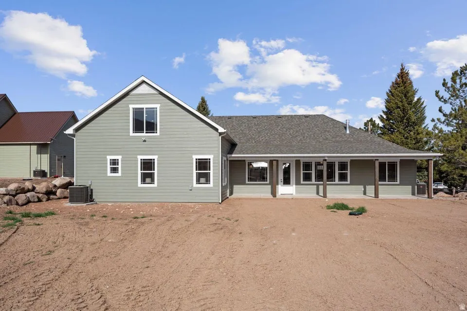 Rear view of property with roof with shingles and a patio