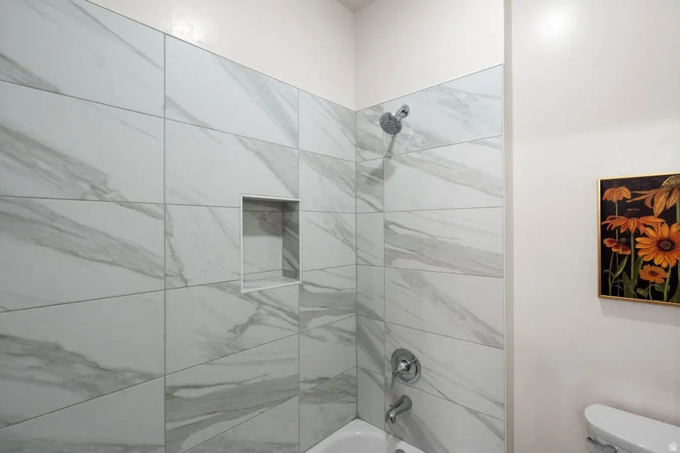 Bathroom featuring shower / bathtub combination and toilet