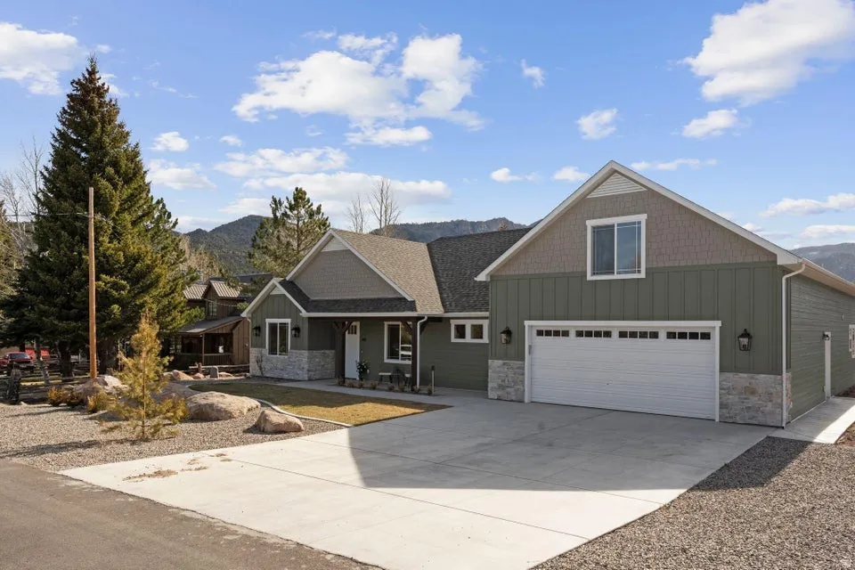 Craftsman inspired home with board and batten siding, stone siding, and a mountain view