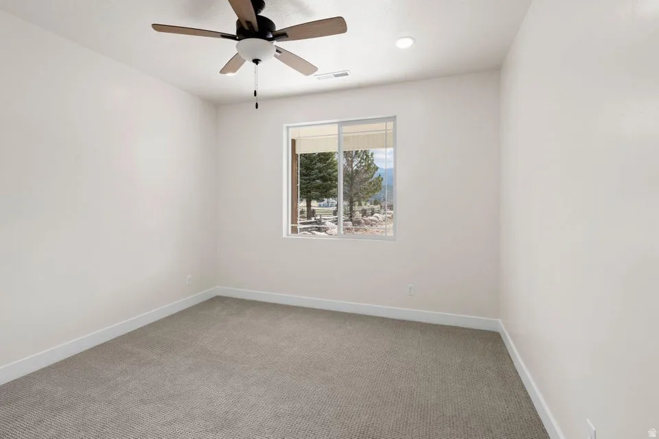 Spare room with light carpet, ceiling fan, and recessed lighting