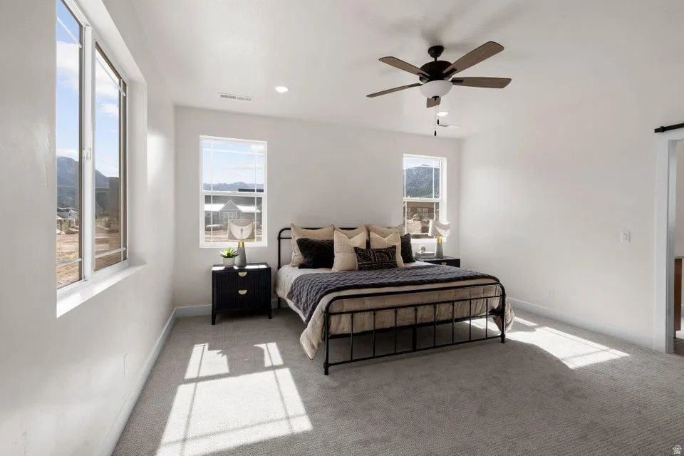 Bedroom with light carpet, a ceiling fan, and recessed lighting