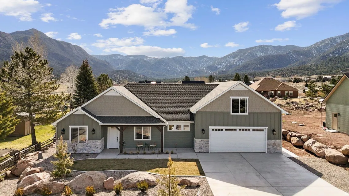 Craftsman-style home with stone siding, a porch, a mountain view, and board and batten siding