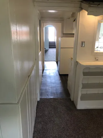 Hall featuring dark colored carpet and arched walkways