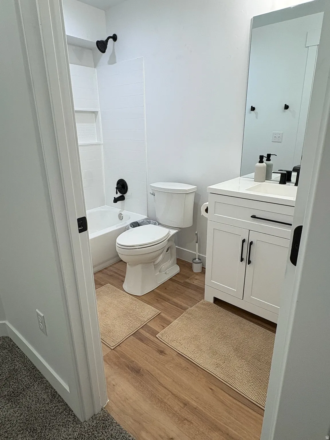 Full bath with vanity,  shower combination, and light wood-style flooring