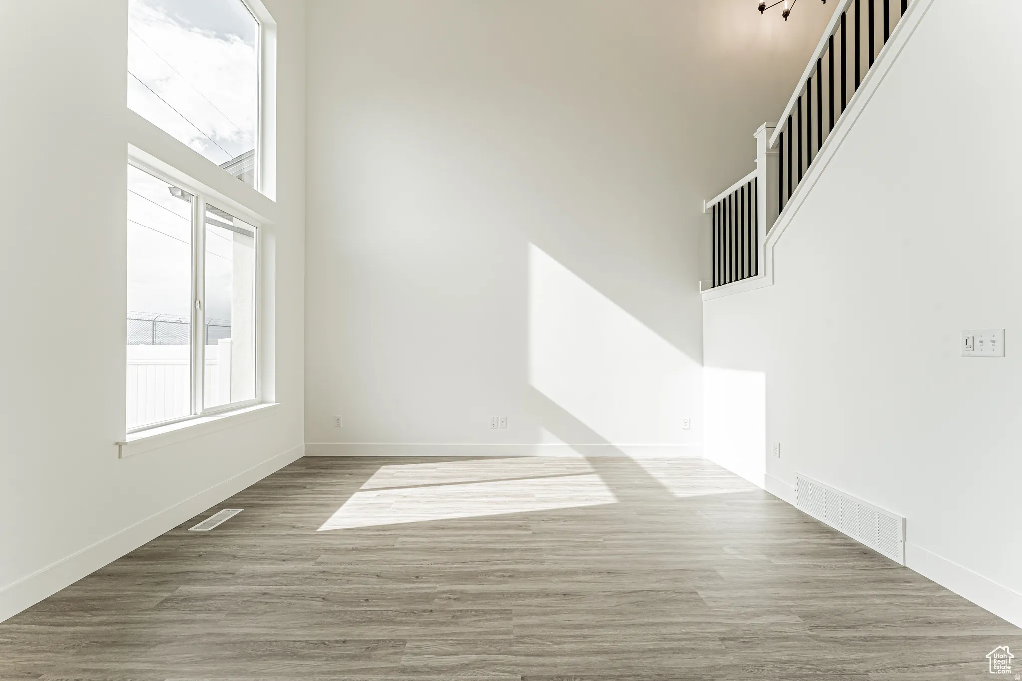 Empty room featuring a high ceiling and light wood-style flooring