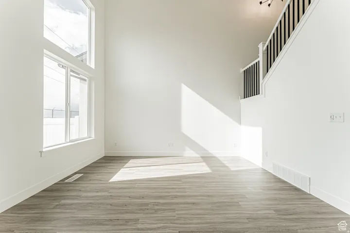 Empty room featuring a high ceiling and light wood-style flooring