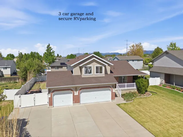 Two-story residence featuring a three-car garage and a paved driveway