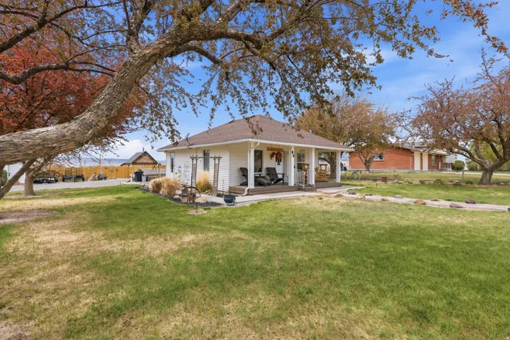 Back of property with covered porch and roof with shingles