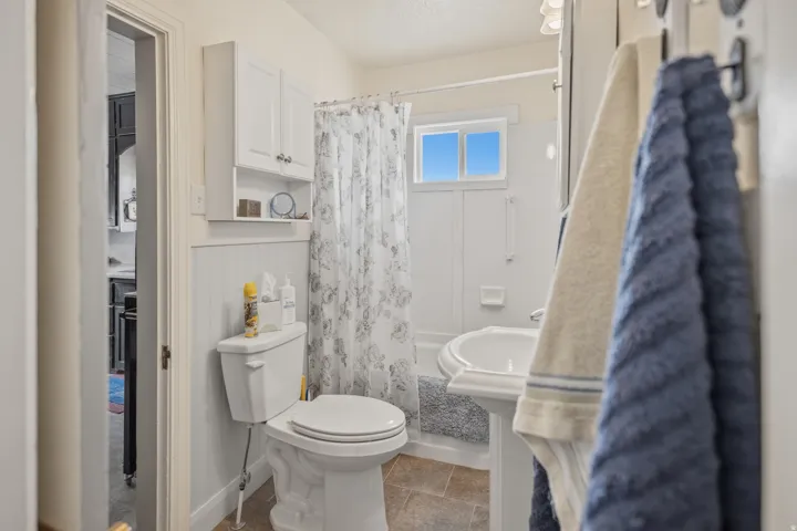 Bathroom featuring shower / tub combo and a textured ceiling