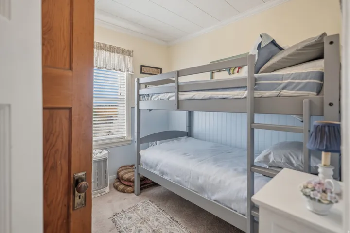 Bedroom with crown molding and light colored carpet