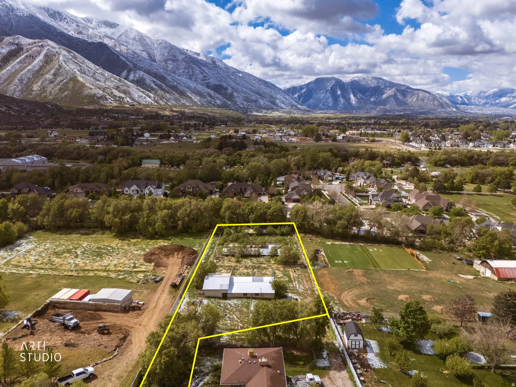 Aerial perspective of suburban area with property parcel outlined and a mountainous background