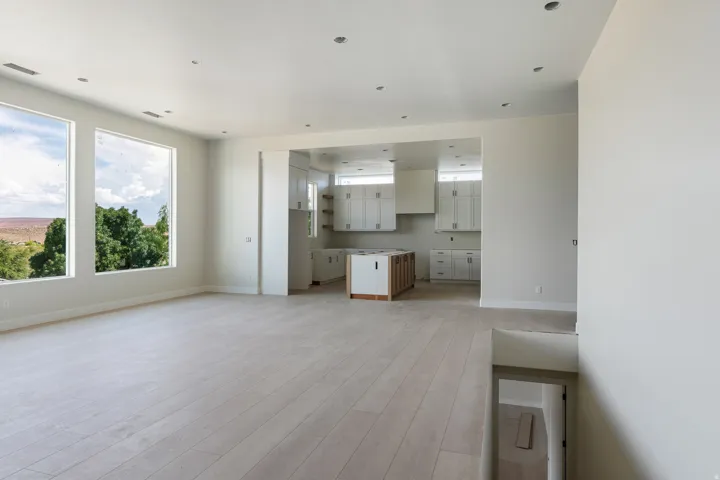 Spacious open-concept area featuring light wood-finish flooring and recessed lighting