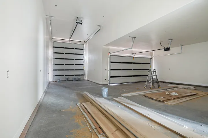 Spacious two-car garage featuring segmented overhead doors and automatic openers