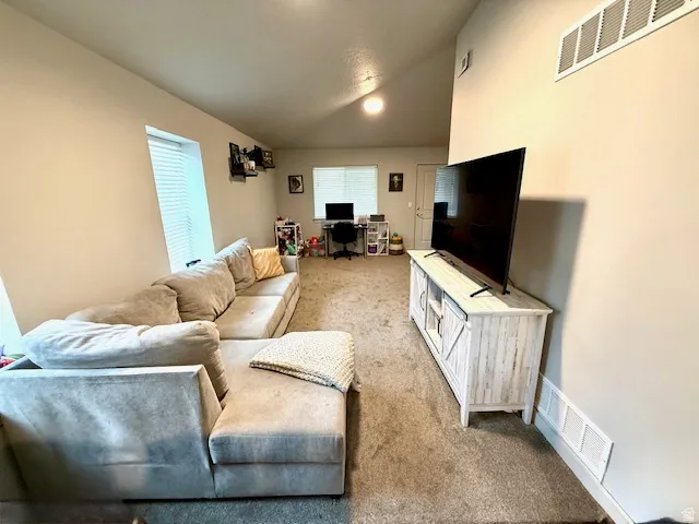 Living room with carpet and lofted ceiling