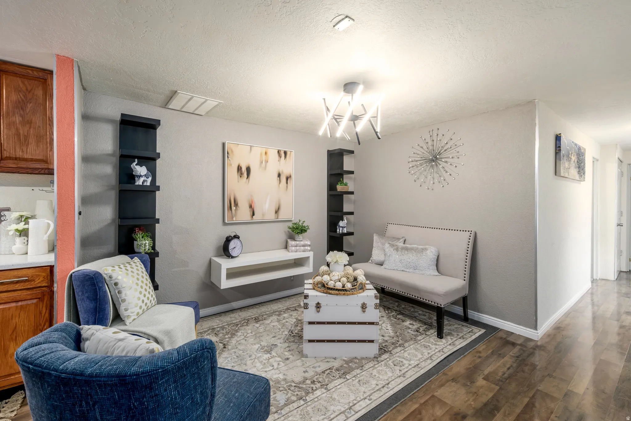 Sitting room featuring wood finished floors, a textured ceiling, and suspended lighting