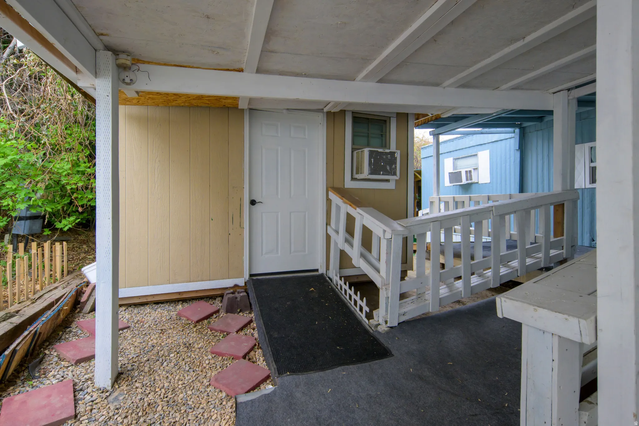 Entrance to property featuring a porch and cooling unit