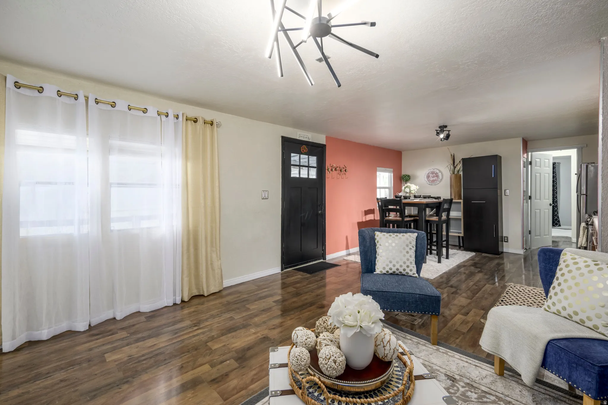Living area featuring dark wood-style flooring and a textured ceiling