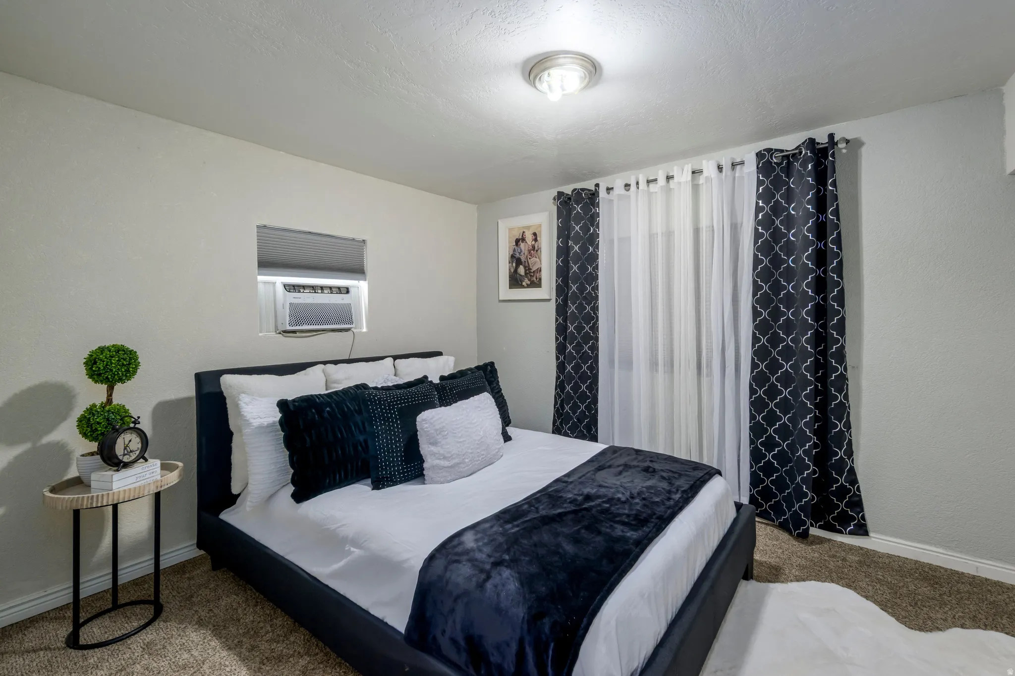 Carpeted bedroom featuring cooling unit and a textured ceiling
