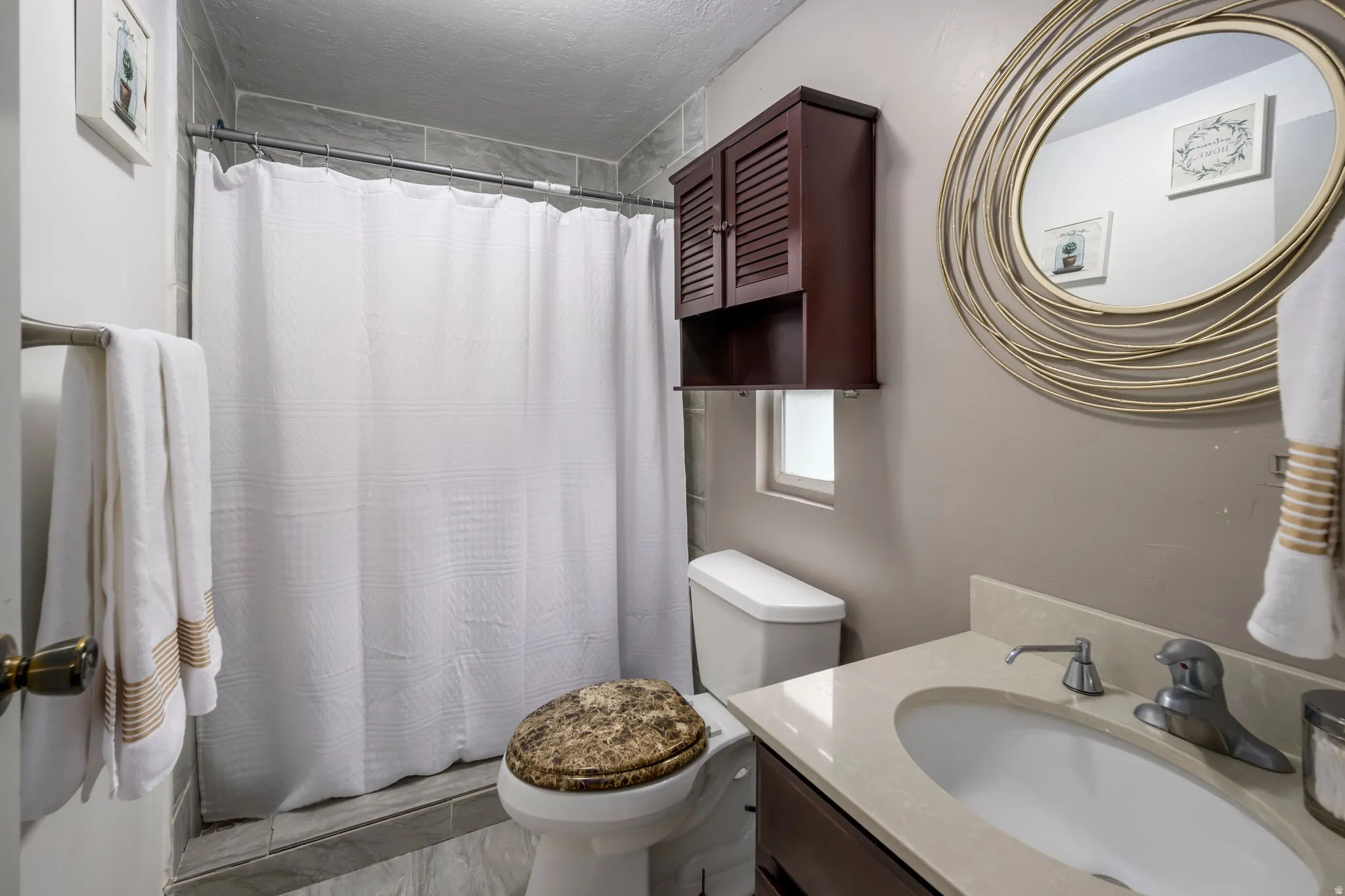 Full bathroom featuring curtained shower and vanity