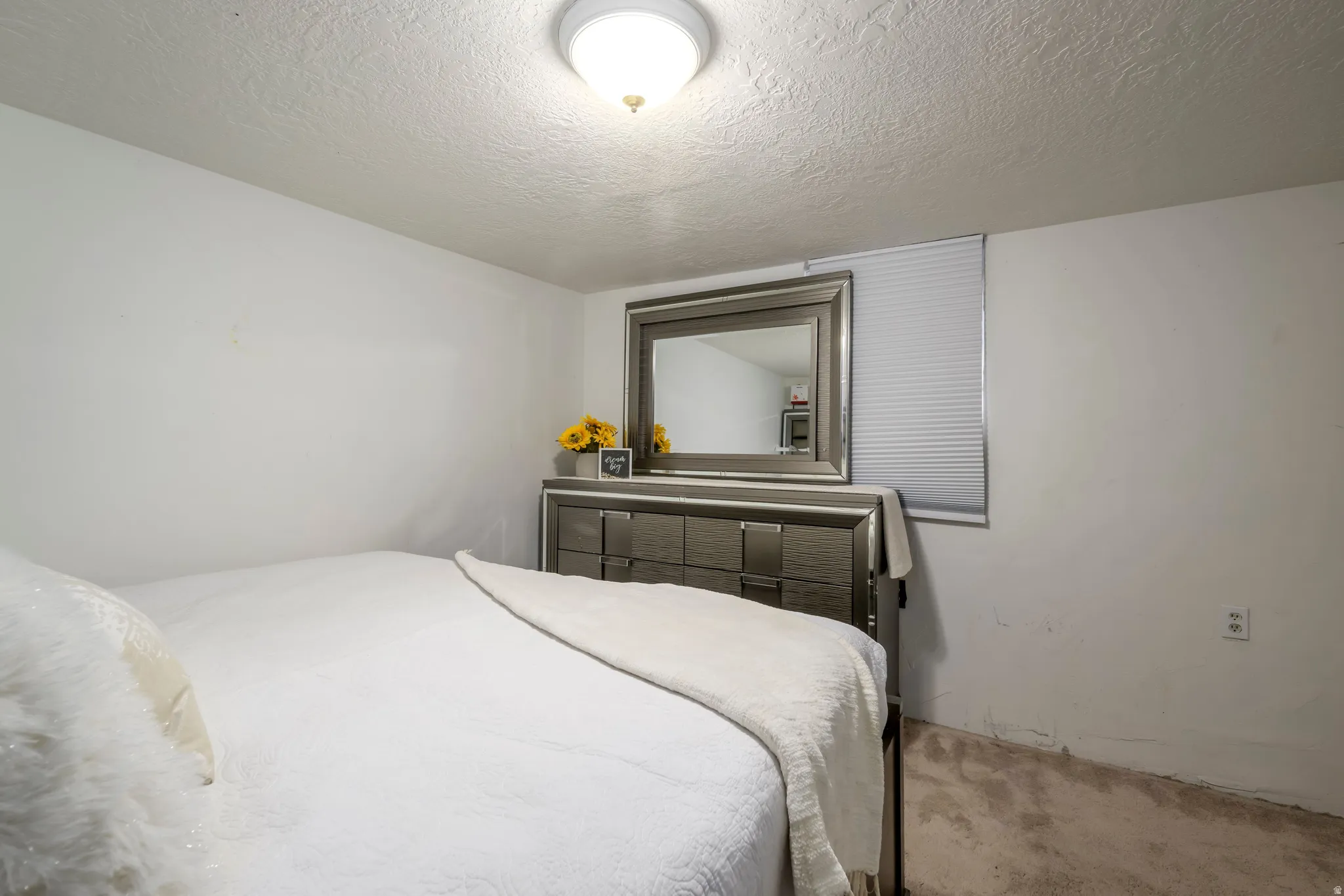 Bedroom with carpet floors and a textured ceiling