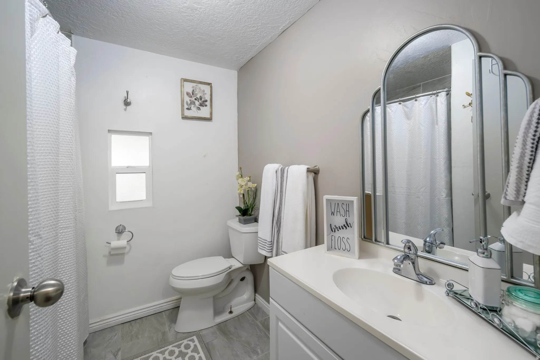 Full bathroom featuring vanity, a textured ceiling, and curtained shower