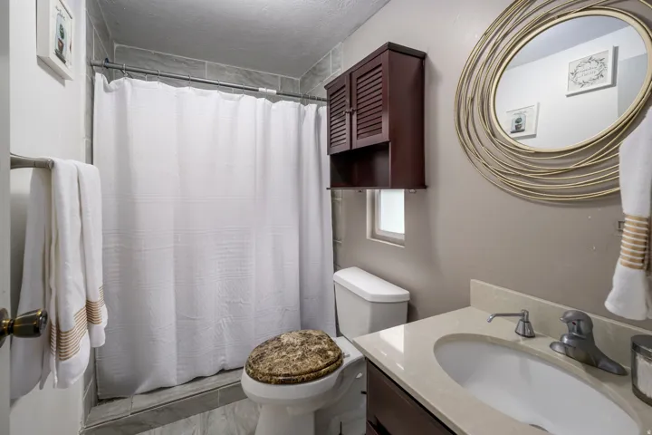 Full bathroom featuring curtained shower and vanity