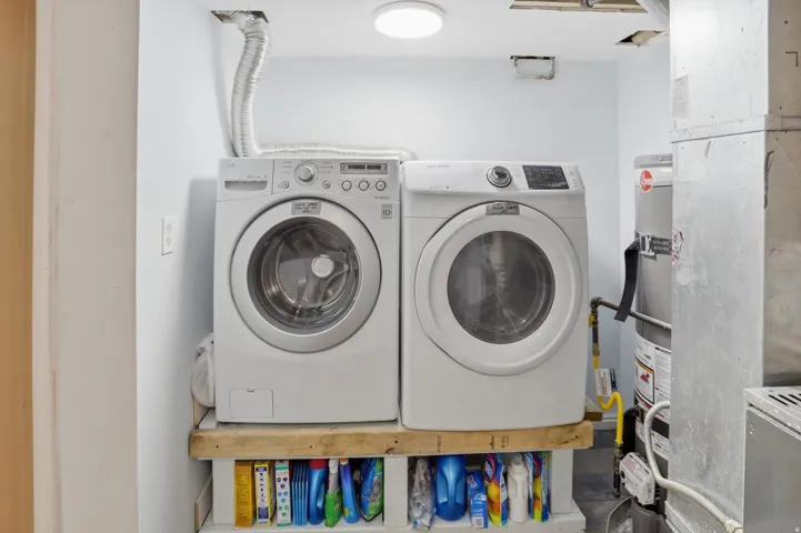 Laundry area featuring washer and dryer and water heater
