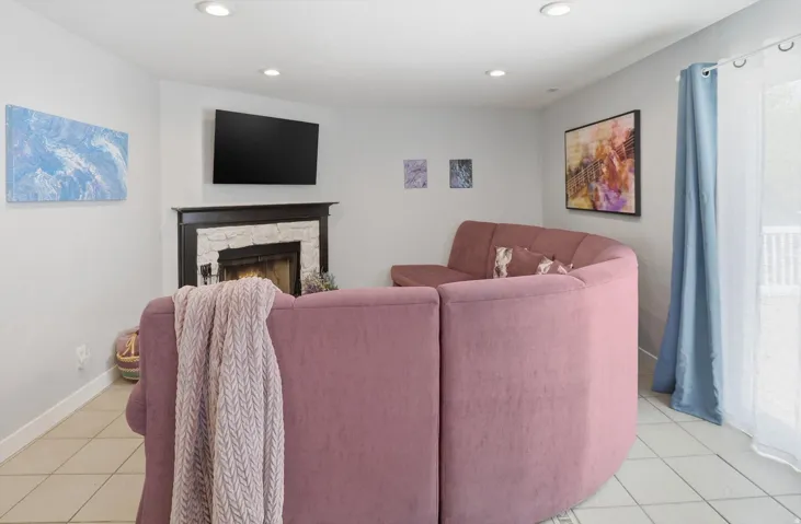 Living room featuring light tile patterned floors, a fireplace, and recessed lighting
