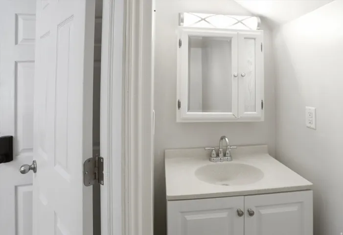 Bathroom featuring vanity and lofted ceiling