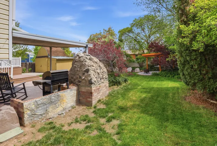 Fenced yard with a patio area and a storage unit