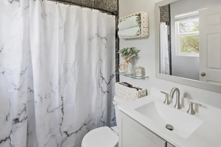 Bathroom featuring a shower with shower curtain and vanity