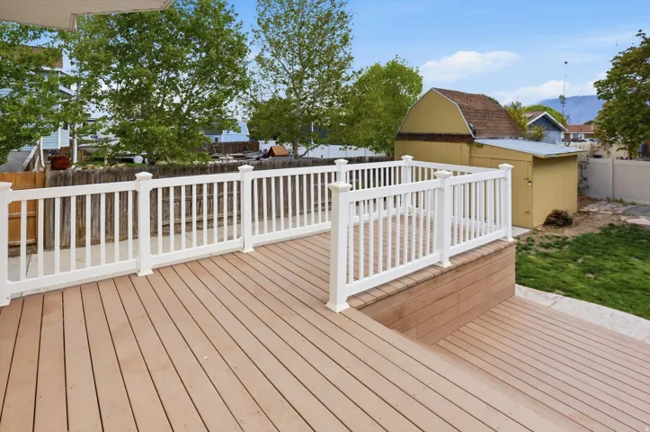Wooden deck with a fenced backyard and a shed
