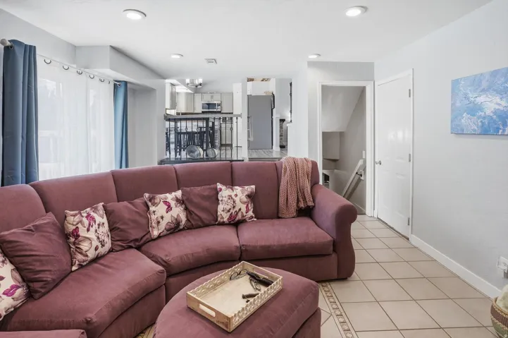 Living room with light tile patterned flooring and a chandelier