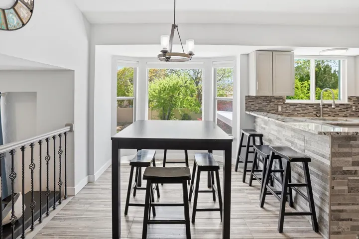 Dining room with suspended lighting and light wood-style flooring