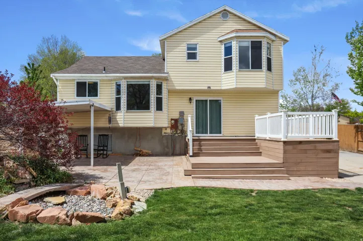 Back of property featuring a patio, a lawn, and a deck