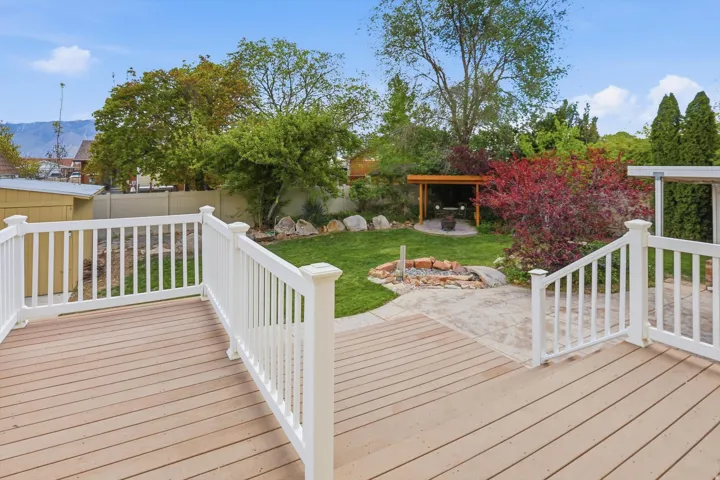 Wooden terrace featuring a fenced backyard, a patio area, and a mountain view